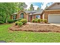 Charming single-story brick home featuring an attached garage, mature trees and a well-manicured lawn at 250 Kari Glen Dr, Fayetteville, GA 30215