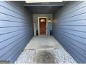 Cozy entryway featuring a wood door, decorative plants, and rock decor at 4092 River Mist Ct, Lithonia, GA 30038
