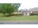 Grassy backyard of home features a covered patio with outdoor furniture and mature trees at 4955 Highland Lakes Dr, South Fulton, GA 30349