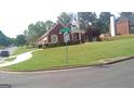 Well-maintained lawn of brick home shows landscaped curb appeal on a corner lot in a neighborhood at 4955 Highland Lakes Dr, South Fulton, GA 30349