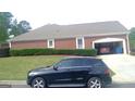 Spacious garage with room for multiple vehicles, attached to a brick home with manicured landscaping at 4955 Highland Lakes Dr, South Fulton, GA 30349