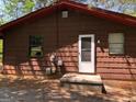 Rear exterior of a one-story house showcasing the wood siding and back door at 6154 Green Acres Sw Dr, Covington, GA 30014