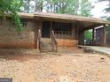Traditional brick home with covered entry, front porch and a yard filled with pine needles at 7225 Pineneedle Sw Dr, Covington, GA 30014
