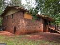 The back of the brick home has an entrance to a basement, and a stair leading to the front at 7225 Pineneedle Sw Dr, Covington, GA 30014