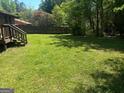 A spacious, grassy backyard with a wooden fence and mature trees at 9176 Carr Sw Cir, Covington, GA 30014