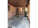 Attached brick carport with concrete flooring, perfect for parking and storage at 9176 Carr Sw Cir, Covington, GA 30014