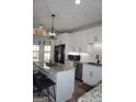 Bright kitchen featuring white cabinetry, granite counters, a kitchen island with seating and stainless steel appliances at 2566 Summit Cove Dr, Duluth, GA 30097