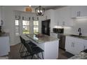 Bright kitchen featuring white cabinetry, granite counters, a kitchen island with seating and stainless steel appliances at 2566 Summit Cove Dr, Duluth, GA 30097