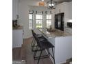 Bright kitchen featuring white cabinetry, granite counters, a kitchen island with seating and stainless steel appliances at 2566 Summit Cove Dr, Duluth, GA 30097