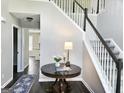 Foyer with a table and a staircase with white railings and dark banisters at 247 Water Oak Ln, Jonesboro, GA 30238