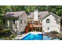 A backyard featuring a deck, an outdoor kitchen, a patio area and a swimming pool at 3644 Graycliff Rd, Snellville, GA 30039
