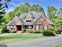 Charming brick home with a well-kept lawn and beautiful landscaping, creating a welcoming curb appeal at 6680 Bentley Trl, Cumming, GA 30040