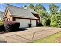 Spacious three-car garage with ample parking space and a well-maintained driveway at 6680 Bentley Trl, Cumming, GA 30040