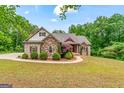 Charming brick home featuring manicured landscaping and a welcoming front porch at 1233 Butler Bridge Rd, Mcdonough, GA 30252