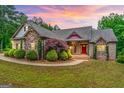 Charming brick home featuring manicured landscaping and a welcoming front porch at dusk at 1233 Butler Bridge Rd, Mcdonough, GA 30252