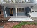 A detailed view of the front porch and entrance with brick and blue siding at 1329 Springwood Nw Dr, Conyers, GA 30012
