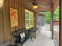 The covered porch features a ceiling fan and seating area to enjoy the outdoors at 712 Honeysuckle Ln, Temple, GA 30179
