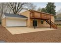 Spacious backyard featuring a large patio, a wood deck with stairs, and an attached two-car garage at 1607 Hillview Ave, Jonesboro, GA 30236