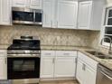 Close-up of modern stainless steel appliances and stylish counters in this well-equipped kitchen at 1607 Hillview Ave, Jonesboro, GA 30236