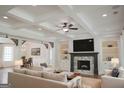An elegant living room featuring a stone fireplace, coffered ceiling, and lots of natural light at 368 Ginger Cake Rd, Fayetteville, GA 30214