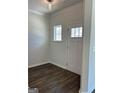Bright entryway with a dark wood floor, white trim, and a door with glass window panes at 3706 Cheswoilde Ave # 96, Powder Springs, GA 30127