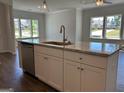 Kitchen island featuring a stainless steel dishwasher, white cabinets, granite counters, and pendant lights at 3706 Cheswoilde Ave # 96, Powder Springs, GA 30127