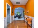 Foyer with gleaming hardwood floors and orange walls, transitioning to the living room with an arched doorway at 702 Brambling Way, Stockbridge, GA 30281