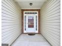 View of the front door with white trim, sidelights, and a brick surround, offering a welcoming entrance to the home at 702 Brambling Way, Stockbridge, GA 30281