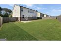 Large, open backyard featuring a concrete patio and wood fence, perfect for outdoor activities at 376 Layfield Dr, Jonesboro, GA 30238