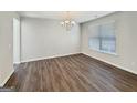 Bright dining room featuring wood floors, a modern chandelier, and a large window at 376 Layfield Dr, Jonesboro, GA 30238