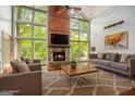 Sun-drenched living room features floor-to-ceiling windows, a stone fireplace, and hardwood floors at 1213 Laurel Cliff Se Dr, Smyrna, GA 30082