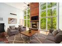 Bright living room with fireplace, large windows offering scenic views and comfortable seating arrangement at 1213 Laurel Cliff Se Dr, Smyrna, GA 30082