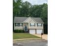 Inviting two-story home with a well-maintained lawn, dual garage doors, and classic architectural details at 140 Clover Valley Dr, Covington, GA 30016