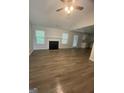 Bright living room featuring a fireplace, hardwood floors, and large windows for natural light at 140 Clover Valley Dr, Covington, GA 30016