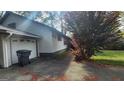 Home exterior featuring a side view of the house, driveway, and attached garage at 402 Emmett St, Riverdale, GA 30274