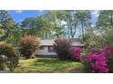 Charming home with beautiful landscaping, colorful azaleas, and mature trees, offering great curb appeal at 402 Emmett St, Riverdale, GA 30274