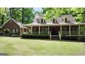 Traditional brick home with a long covered porch and dormer windows at 31 Butler Bridge Dr, Mcdonough, GA 30252