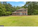 Well-maintained two-story brick home featuring a large front yard with mature trees at 155 Grandview Trce, Fayetteville, GA 30215