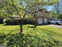 This house features a neat front lawn, mature trees, and an attached two-car garage at 4457 Huntshire Dr, Stone Mountain, GA 30083