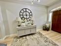 Inviting entryway with stylish console table, decorative clock, and wooden floors at 109 Old Virginia Cir, Jonesboro, GA 30236