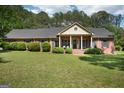 Well-maintained single-story brick home with manicured lawn, mature landscaping, and a covered front porch at 109 Old Virginia Cir, Jonesboro, GA 30236