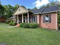 Traditional brick home with a front porch and pillars surrounded by manicured green bushes at 109 Old Virginia Cir, Jonesboro, GA 30236