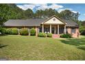 Inviting front lawn of a single-story brick home with a covered porch, manicured lawn, and mature trees at 109 Old Virginia Cir, Jonesboro, GA 30236