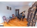 Living room featuring a black baby grand piano and elegant decor, creating a refined and inviting space at 105 Kellens Ct, Fayetteville, GA 30215
