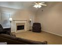 Cozy living room featuring a fireplace, carpeted floor, ceiling fan, and natural light from the window at 1129 River Green Ct, Mcdonough, GA 30252