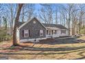 Exterior view featuring stone facade, inviting front porch, and landscaping at 84 Contour Dr, Stockbridge, GA 30281