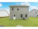 The backyard features a level, grassy lawn, and the rear exterior of a home with simple, clean lines at 311 Limestone Circle, Conyers, GA 30013