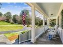 Inviting front porch with stone flooring, white columns, and rocking chairs at 1664 W Wesley Nw Rd, Atlanta, GA 30327