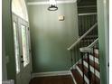 Elegant foyer featuring a decorative front door and a staircase with iron railings at 760 Swan Ln, Canton, GA 30115