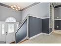 Home entryway featuring grey walls and carpeted floors with a staircase and front door at 227 River Trace Ct, Mcdonough, GA 30253